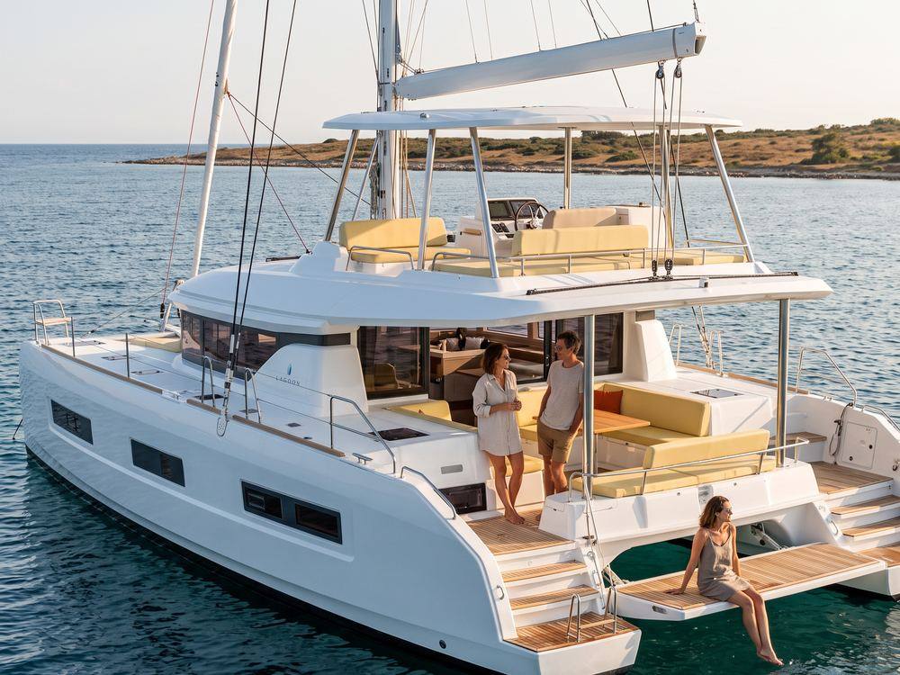 Guests sitting out in the shaded cockpit of a chartered catamaran at anchor in the late afternoon