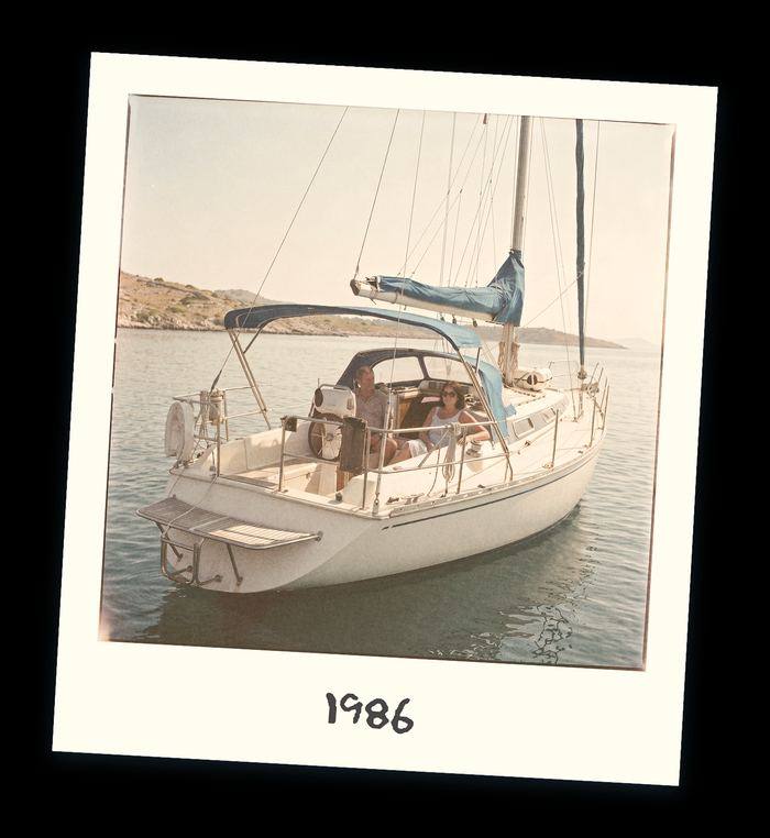 Polaroid of the family's first sailing boat moored on a Greek quay in 1986